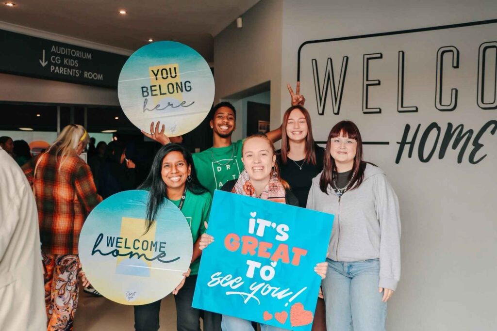 Young adults and volunteers welcoming visitors at Christ Gen Church, a family-focused church in Cape Town near Parow