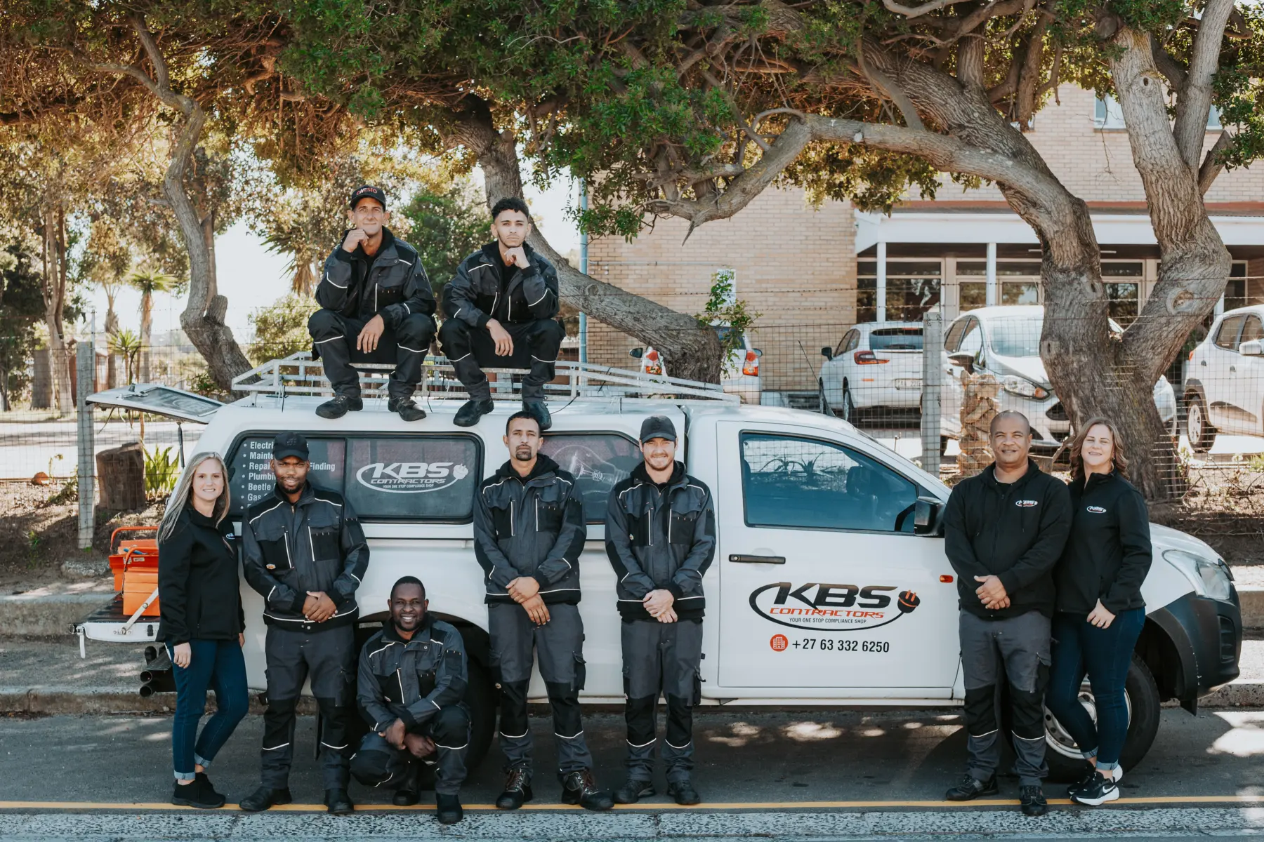 Team photo of KBS Electrical Contractors Cape Town posed around a utility truck.